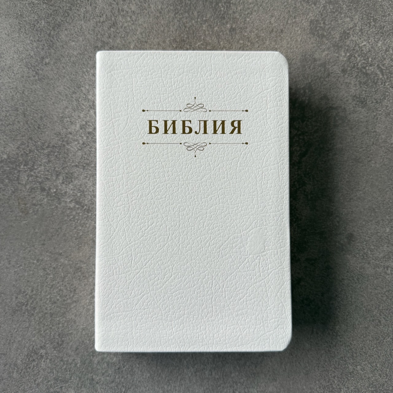 Дисконт. Белое пятнышко на лицевой обложке справа по центру. Библия 048 код 25048-21 дизайн "Библия с вензелем", кожаный переплет, цвет белый пятнистый, формат 125*195 мм