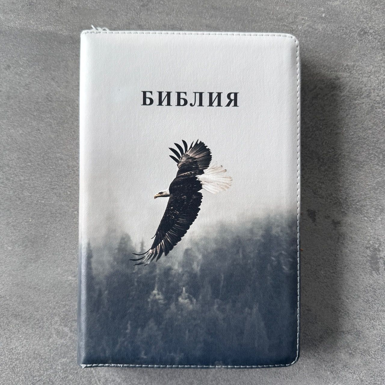 Дисконт Серая точка на лицевой обложке. Библия 055zti код 25055-66  цветная печать "Орел", переплет из искусственной кожи на молнии с индексами, формат 143*220 мм