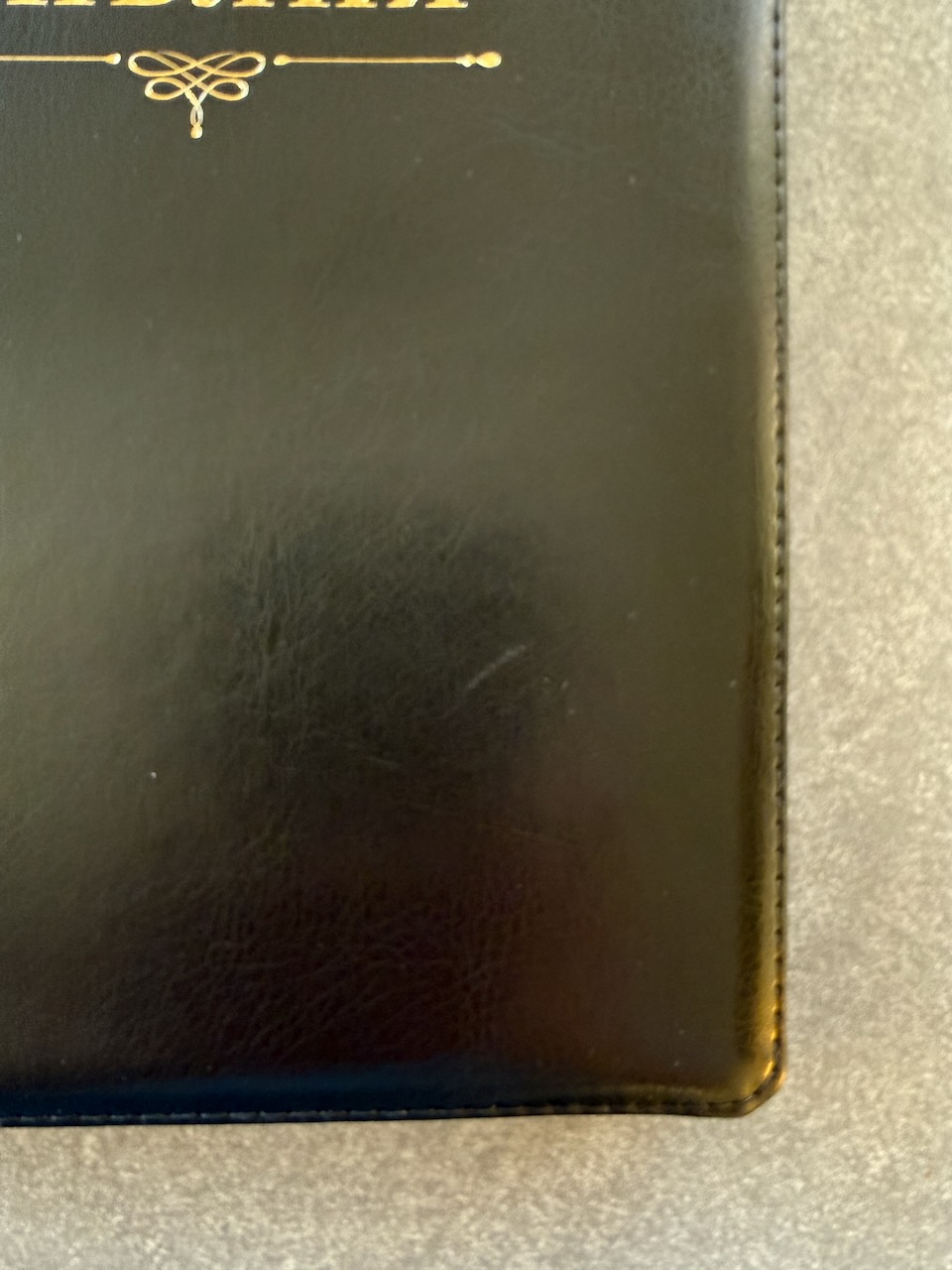 Дисконт. Небольшая полоска (в виде зацепки), в правом углу на лицевой обложке чуть ниже центра. Библия 076z код 23076-37,  надпись "Библия" золотом , переплет из искусственной кожи на молнии, цвет черный, размер 180x243 мм